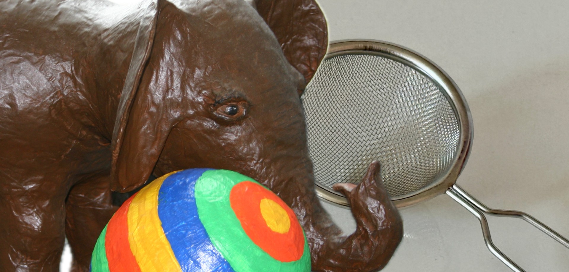 Elefant steht neben einem Teesieb, Collage