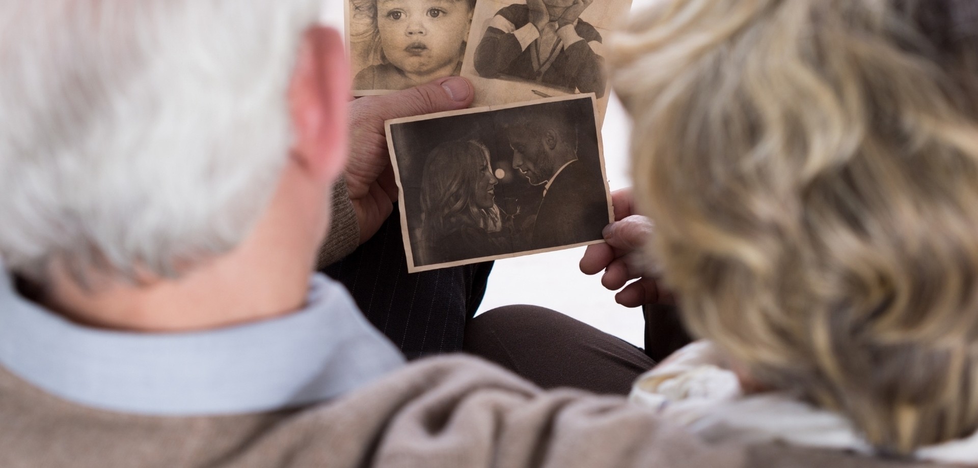 Betagte Menschen schauen sich Erinnerungen an auf Fotos