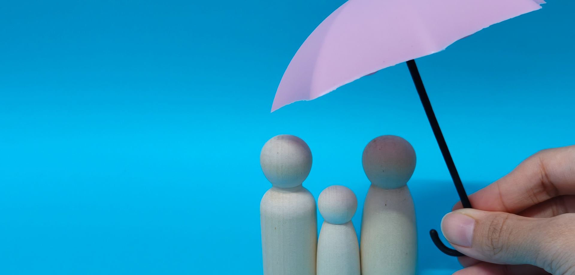 Schirm über Holzpüppchen