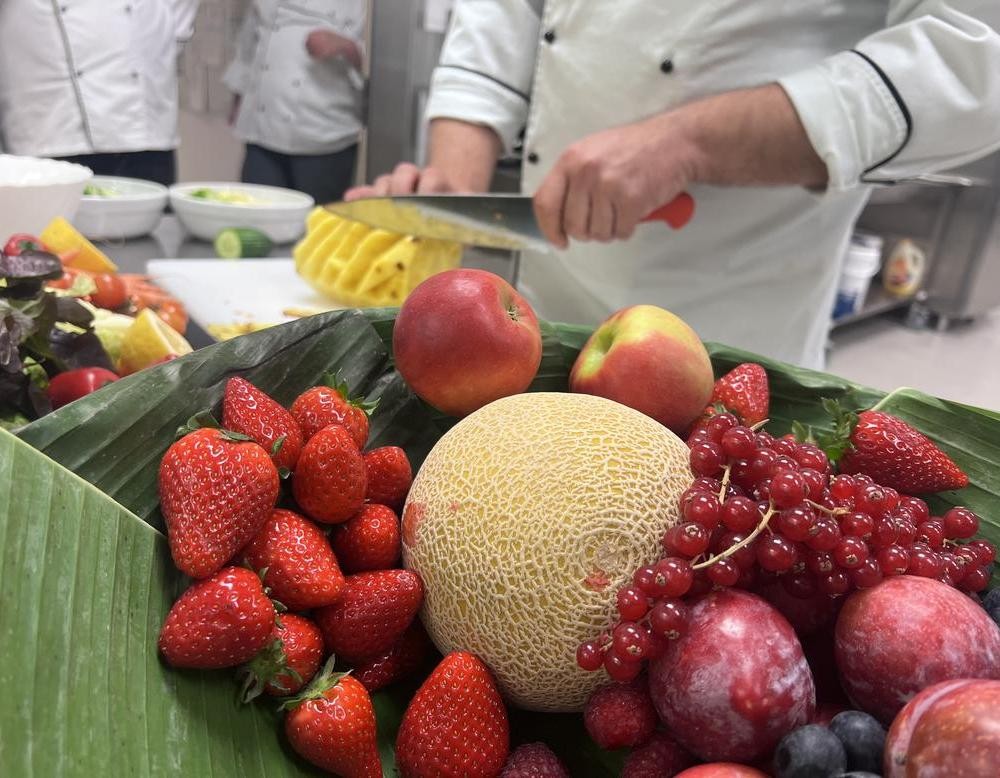 Koch schneidet bunte Früchte