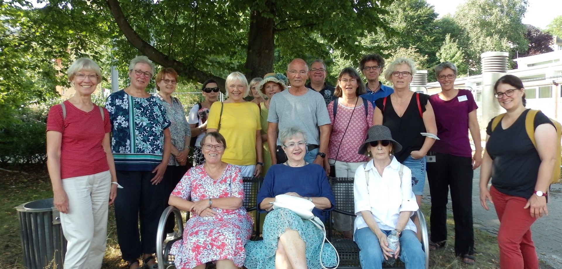 Eine Pilgergruppe steht unter einem grünen Baum