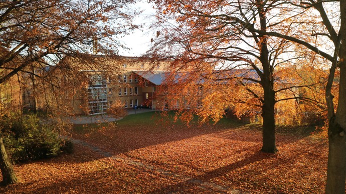 Rückwärtige Ansicht des LWL-Pflegeheims Dortmund, umgeben von herbstlichen Bäumen