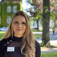 Denise Kolleck schaut in die Kamera, im Hintergrund das Verwaltungsgebäude der Klinik Denise Kolleck schaut in die Kamera, im Hintergrund das Verwaltungsgebäude der Klinik