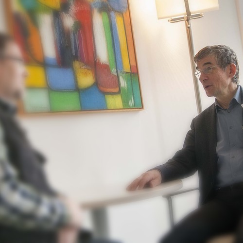Zwei Männer sitzen sich im Gespräch gegenüber. Sie halten Blickkontakt