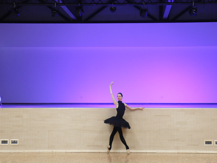 Eine Primaballerina tanzt vor einer Bühne (vergrößerte Bildansicht wird geöffnet)