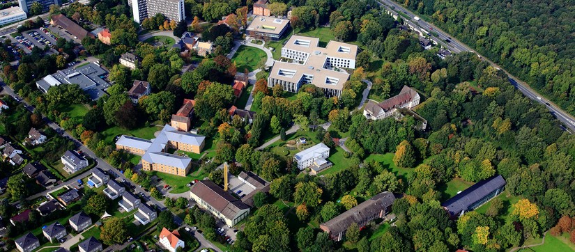 Blick auf die Rezeption und Informationstheke, rechts eine holzgetäfelte Wand