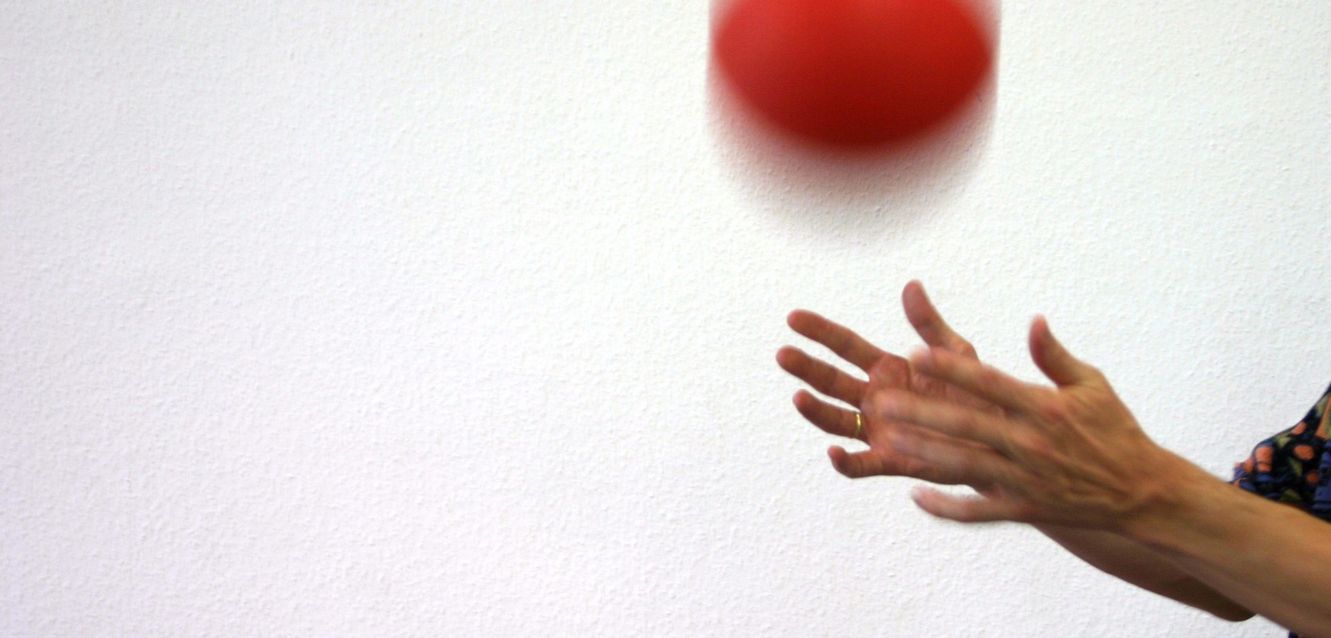 Zwei Hände werfen einen Ball in die Höhe