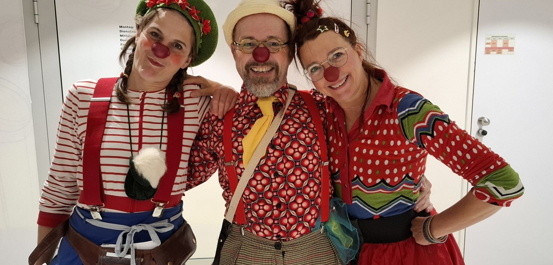 Drei Klinikclowns lächeln freundlich in die Kamera.