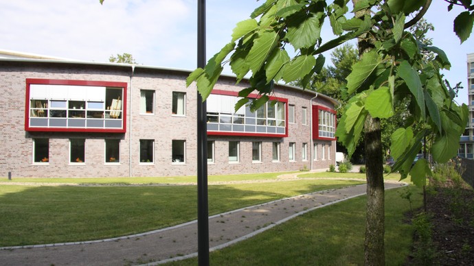 Gartenansicht der runden Fassade der Tagesklinik Unna  mit große Panoramafenstern