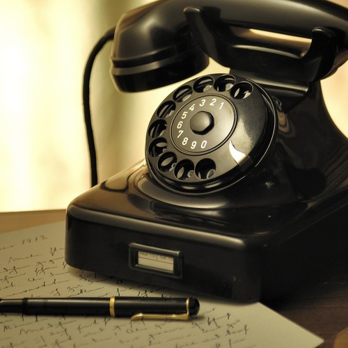 Ein altes, schwarzes Telefon mit Wählscheibe. Der Hörer ist aufgelegt