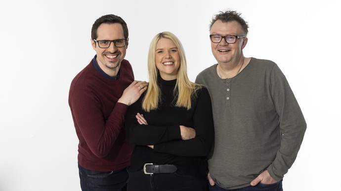 Drei Menschen in Alltagskleidung und mit freundlichem Gesichtsausdruck stehen nebeneinander. Drei Menschen in Alltagskleidung und mit freundlichem Gesichtsausdruck stehen nebeneinander.